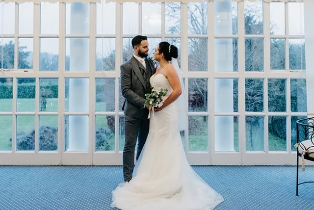 Bride in white wedding dress and groom in grey suit